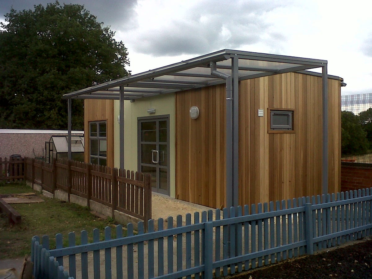 Flat lean-to canopy over a timber-clad outdoor classroom building